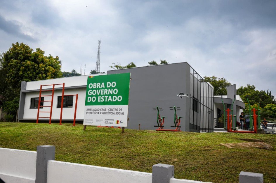 Foto mostra o prédio do CRAS em Encantado que foi reformado com a placa na frente que diz Obra do Governo do Estado
