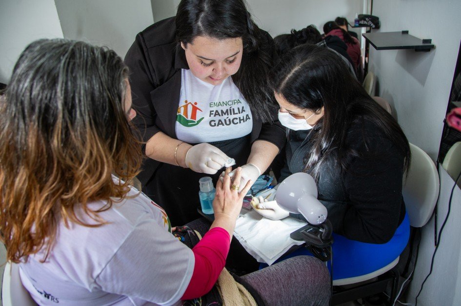 Imagem mostra mulher aprendendo a fazer as unhas de uma cliente