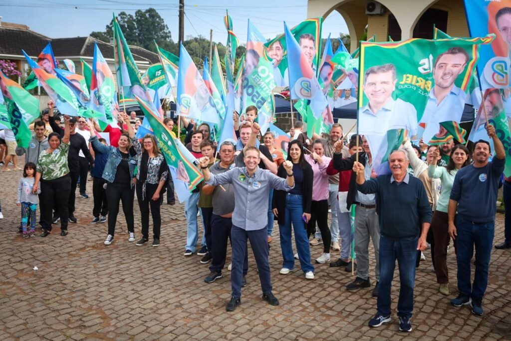 Beto posa ao lado de apoiadores segurando bandeiras