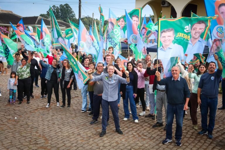 Beto posa ao lado de apoiadores segurando bandeiras